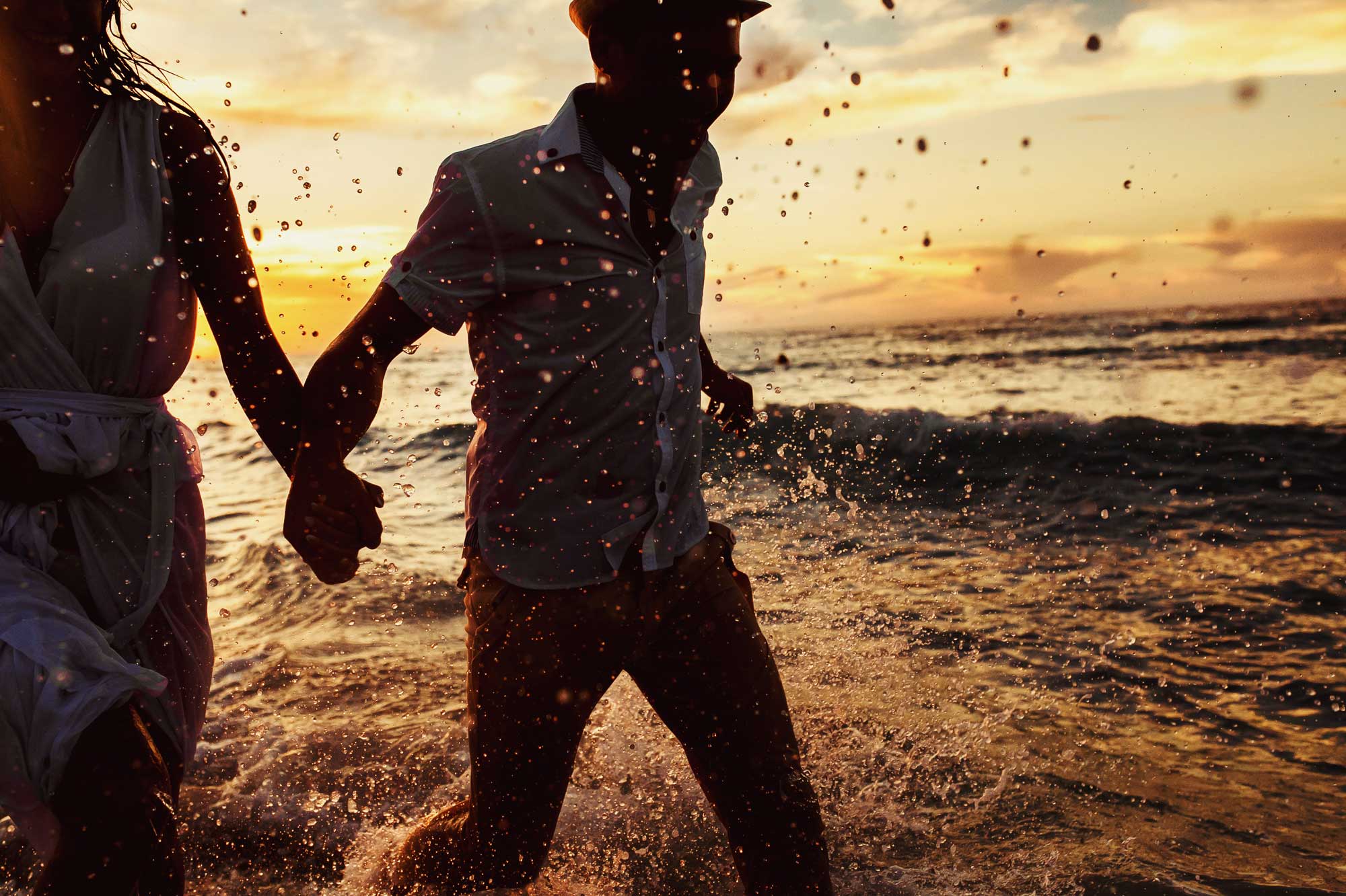 beautiful-sunset-in-the-ocean-and-happy-couple-holding-hands