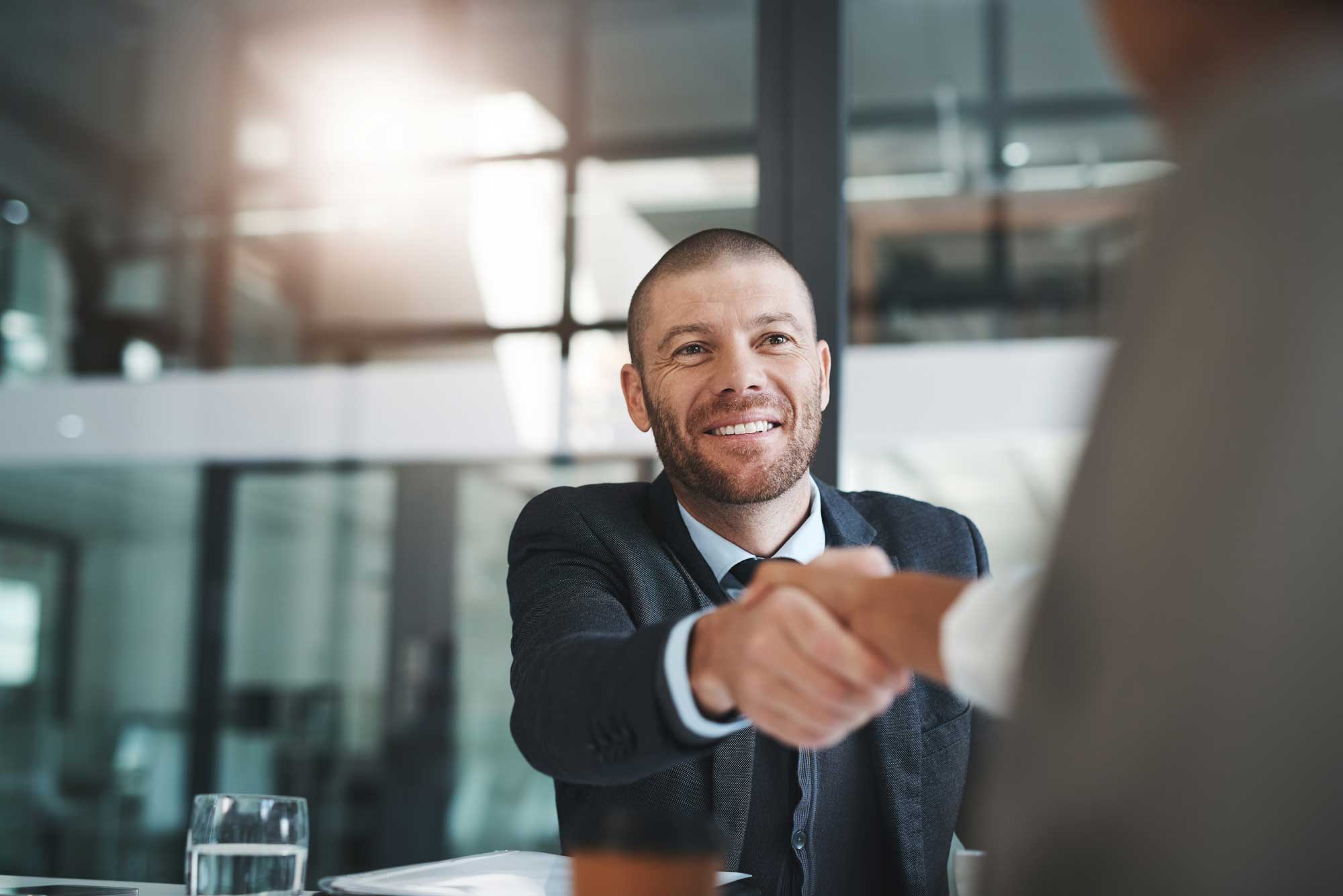 happy-businessman-shaking-hands-in-teamwork-or-introduction-and-welcome